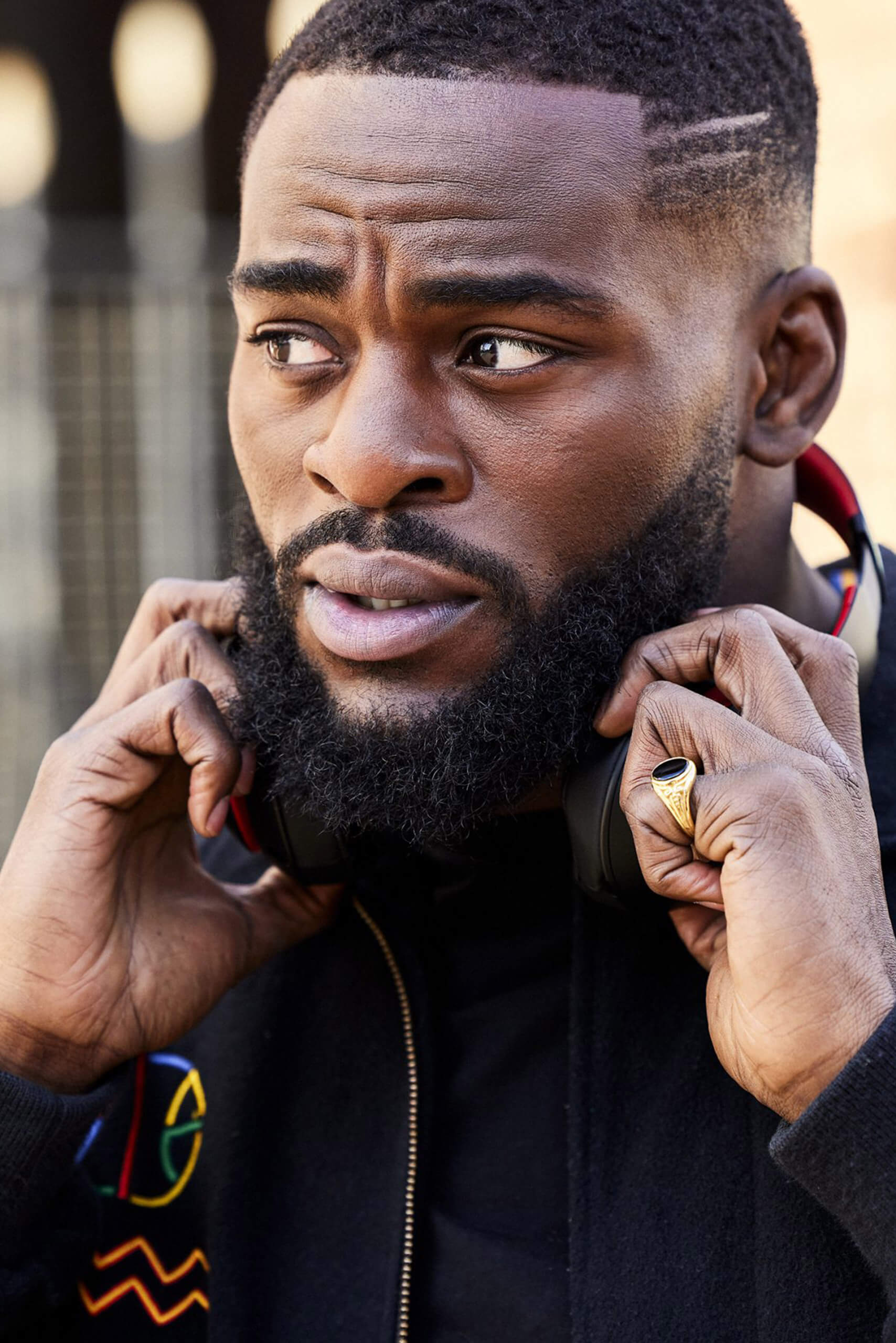 A close up of Joshua Buatsi holding on to some over-ear headphones around his neck