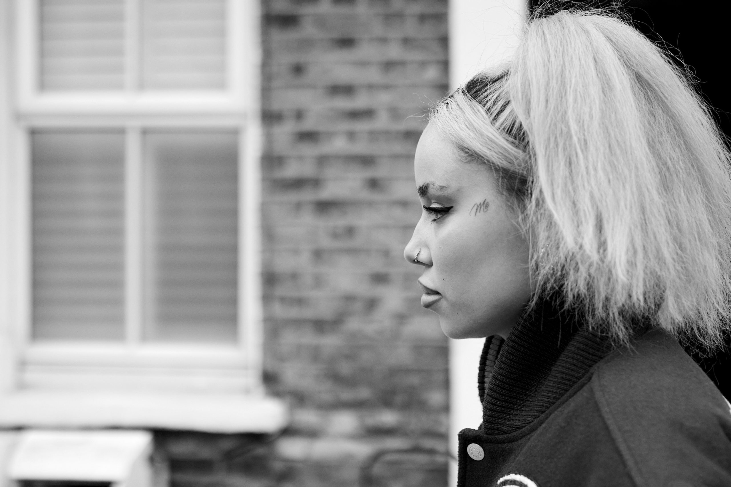 A close up of JGRREY walking in front of some terraced houses