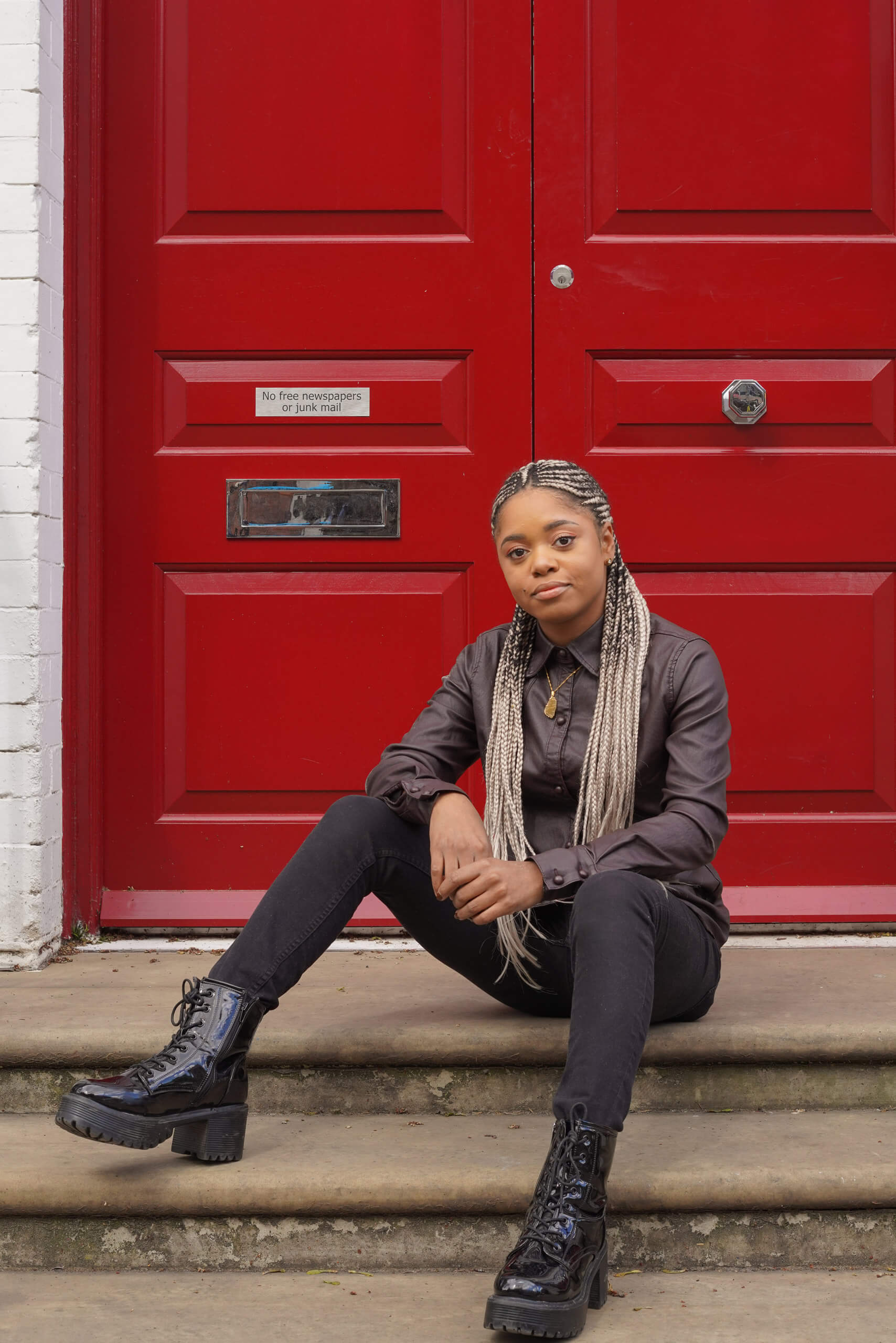 Lauren Marie Haywood looking at the camera in front of a red panelled door