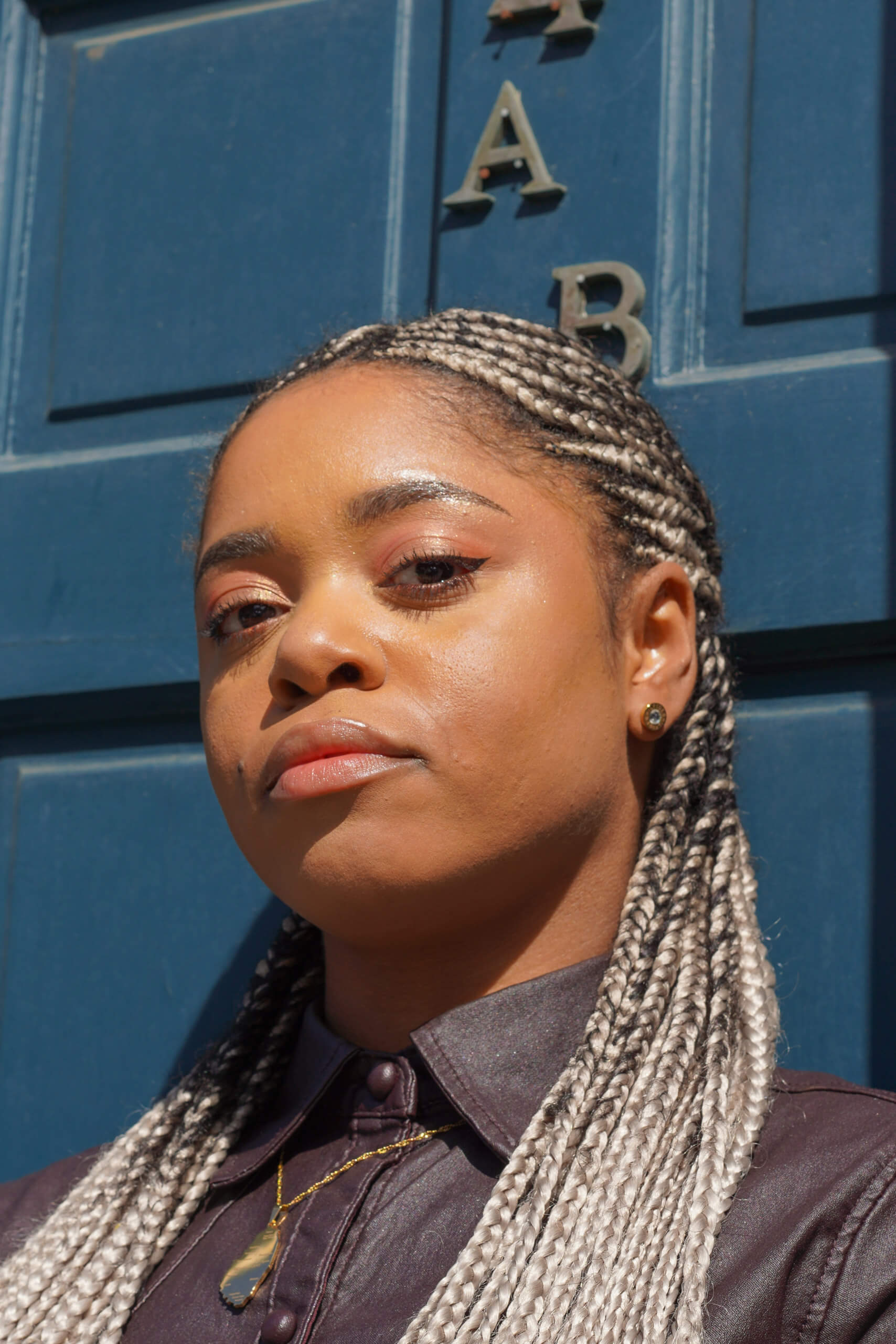 Lauren Marie Haywood looking at the camera stood in front of a blue panelled door