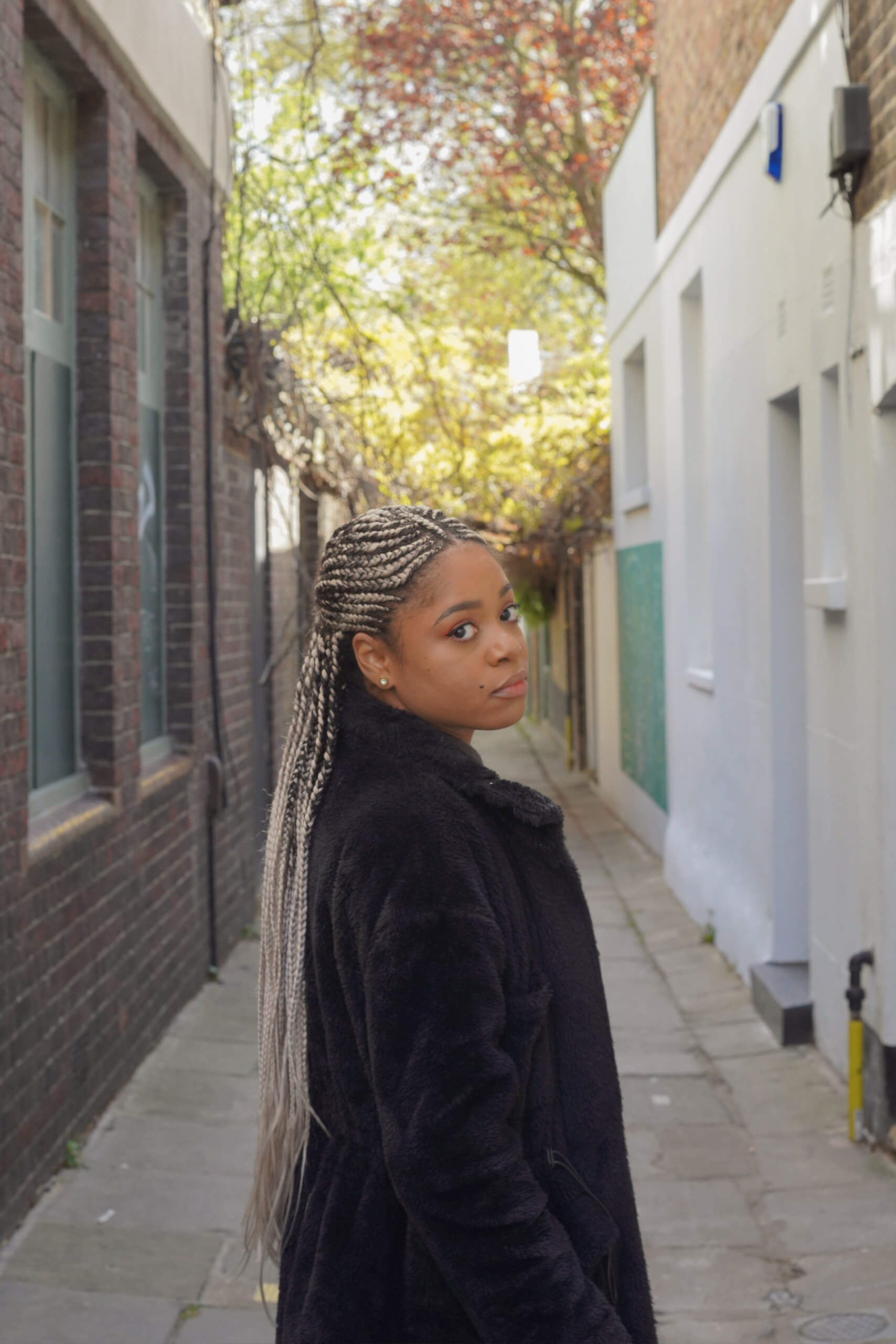 Lauren Marie Haywood in an sunny alleyway looking at the camera