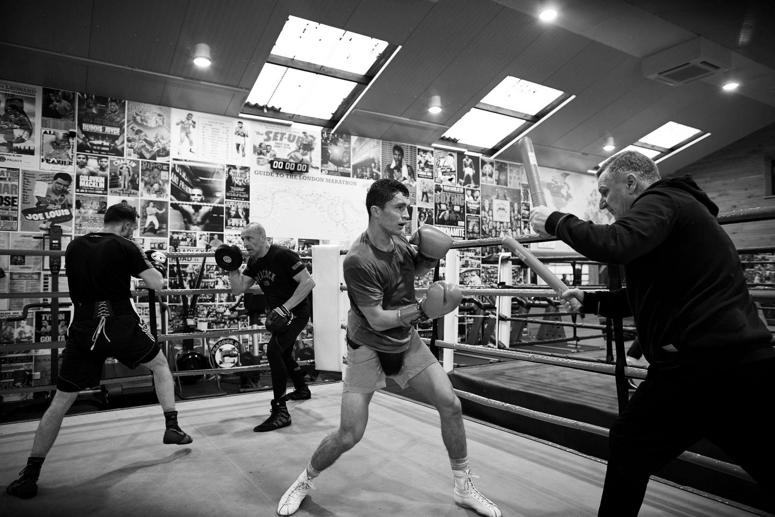 Louie Lynn training with trainers holding practice pads in the boxing ring