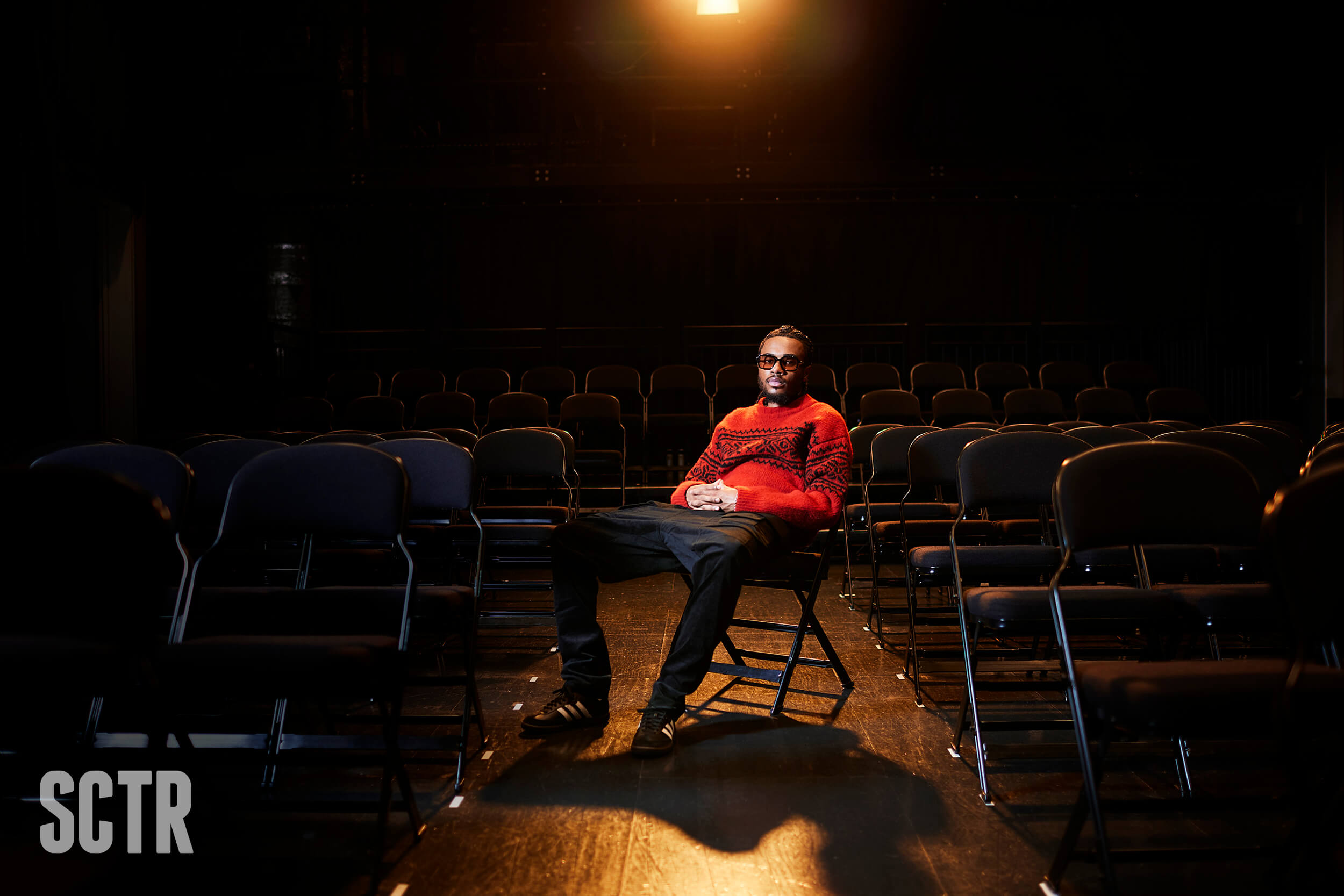 Venna sitting on a chair in a large hall