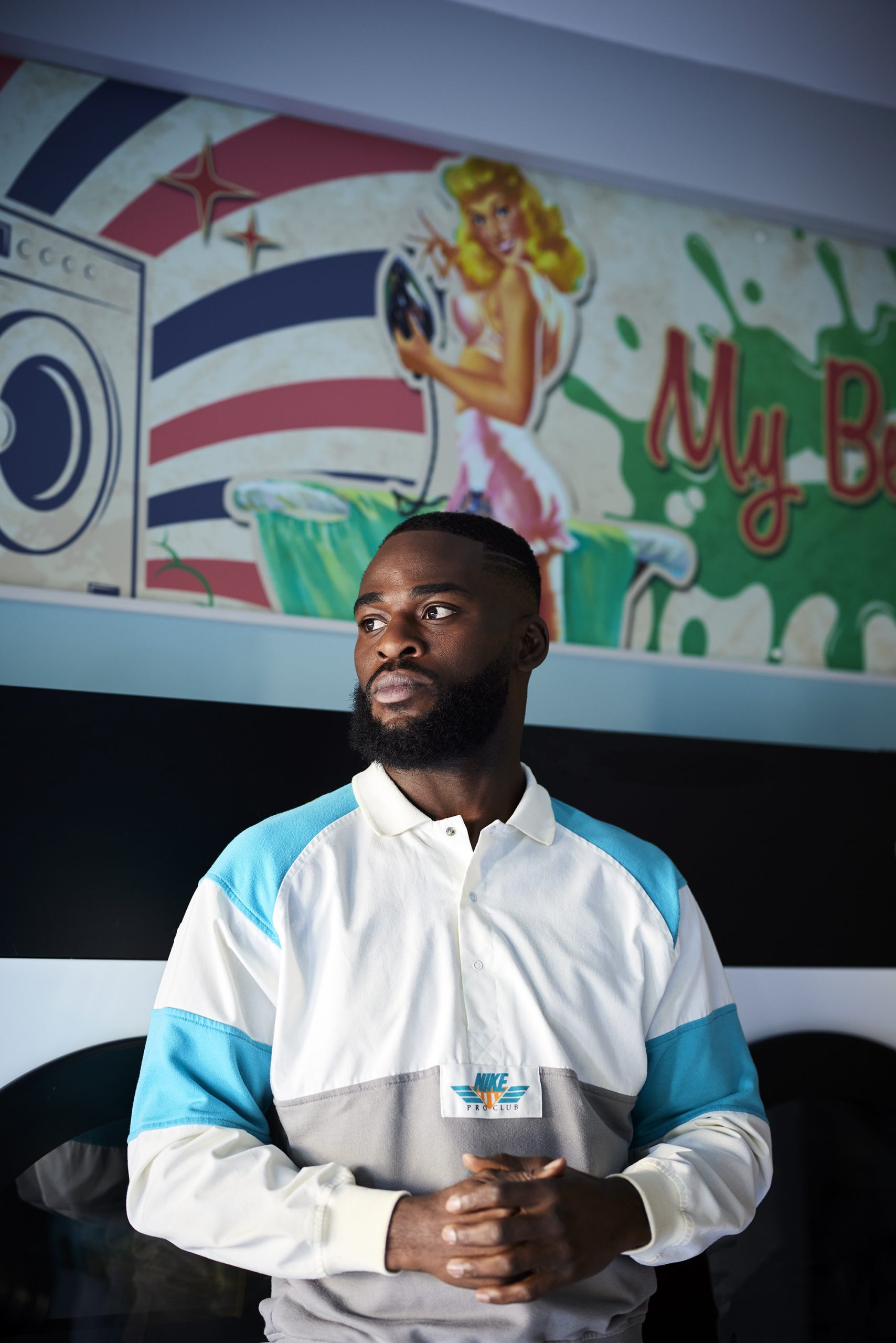 Joshua Buatsi, with clasped hands above his waist, stood in front of some clothes washing machines