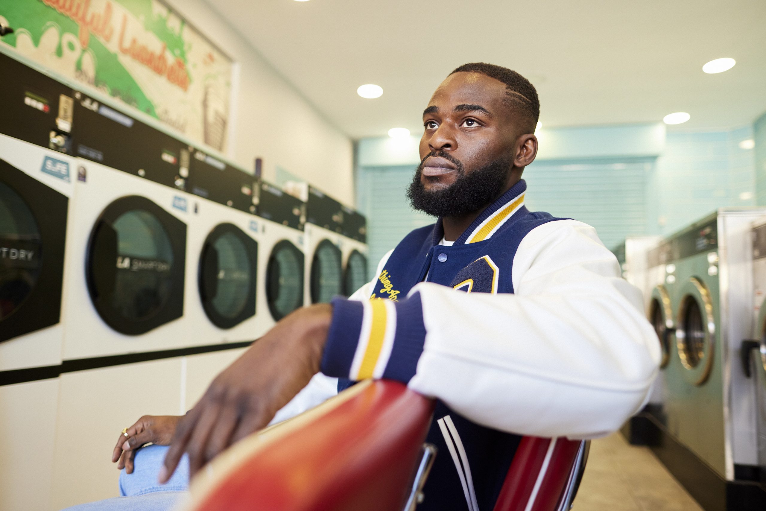 Joshua Buatsi sat on some red plastic chairs in a laundromat