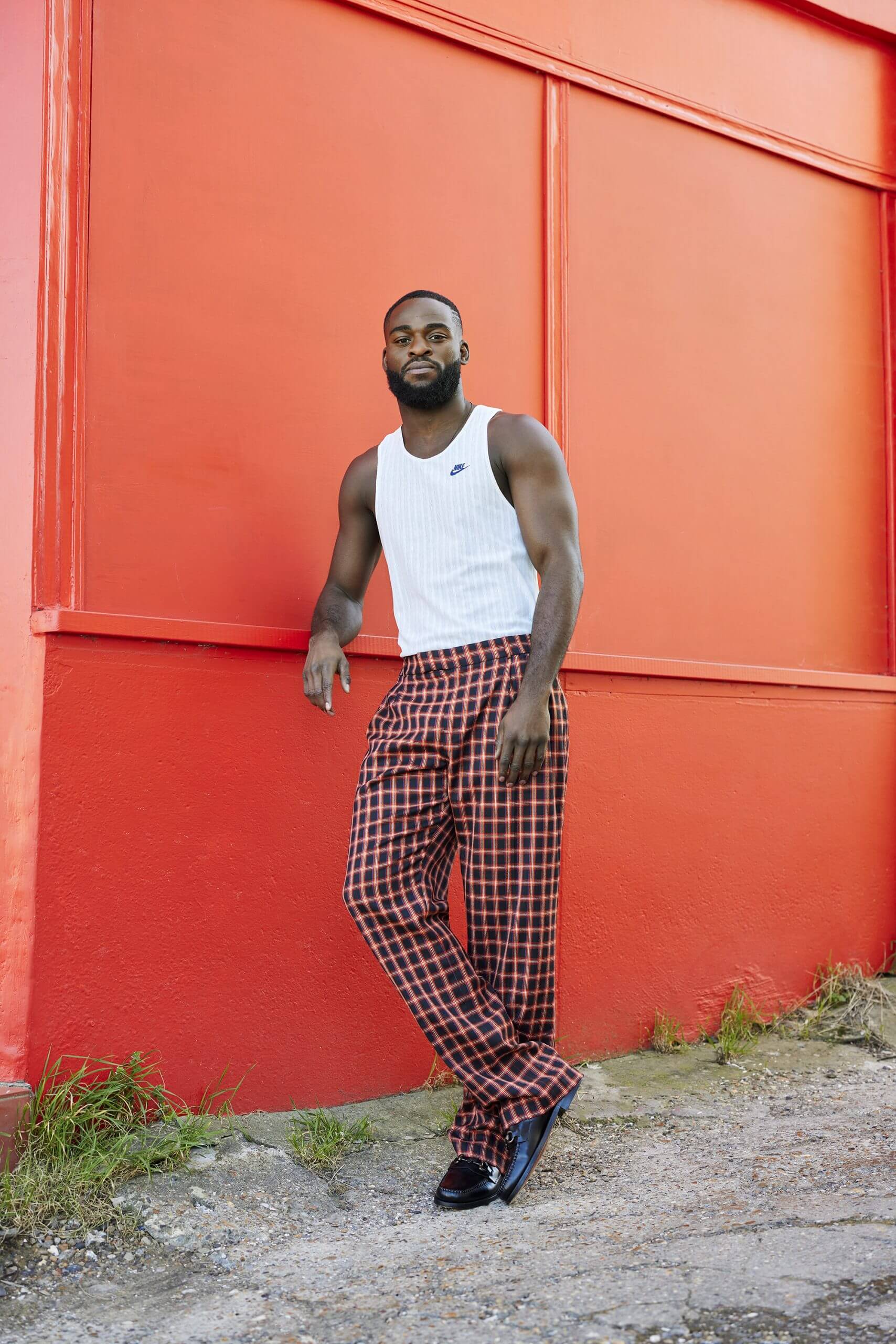 Joshua Buatsi stood in front of a bright orange painted wall outside