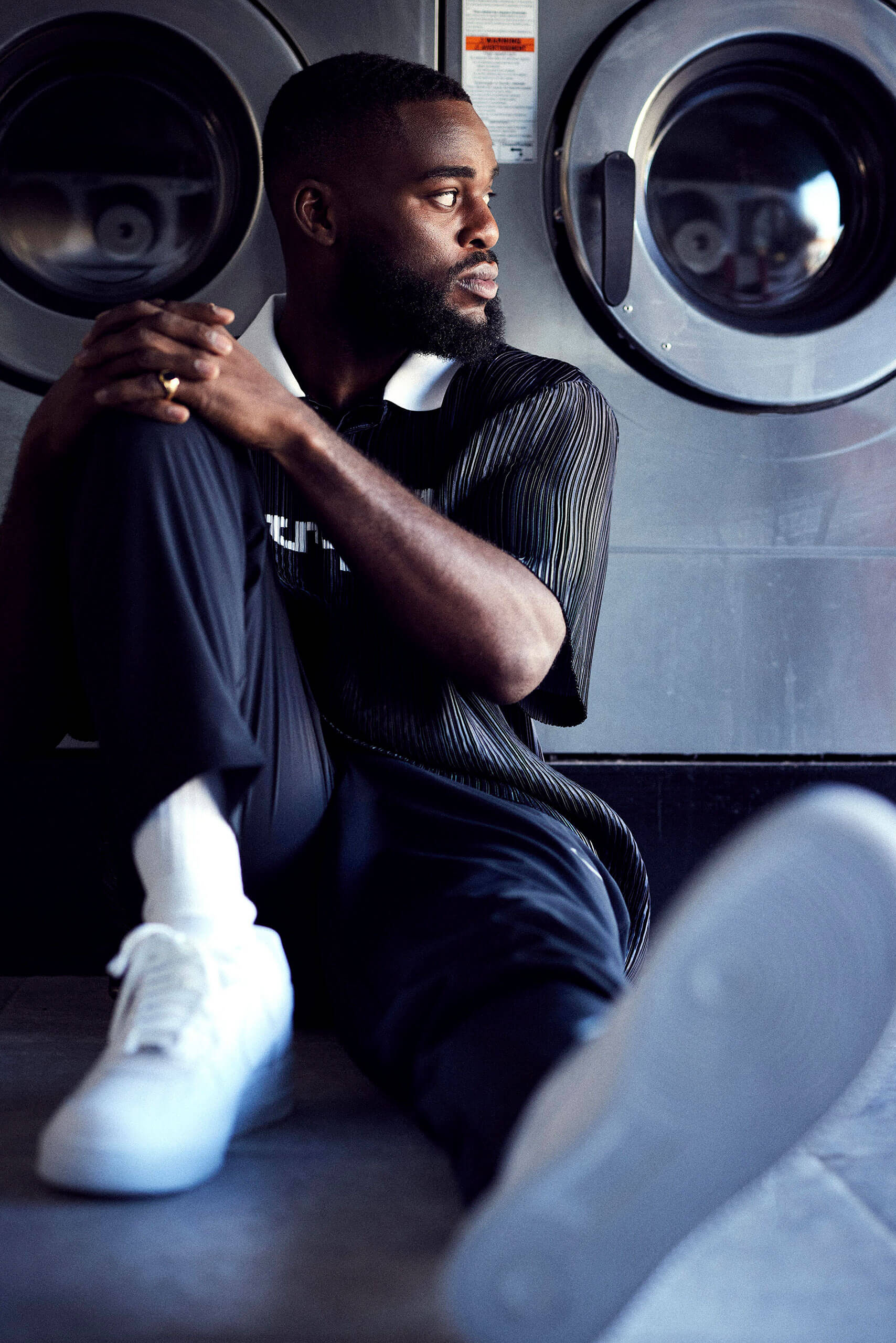 Joshua Buatsi sat on the floor under some clothes washing machines