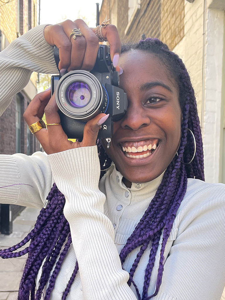 Lara Soluade holding a camera smiling